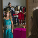 Kind in Prinzessinenkleid in türkis vor Spiegel.